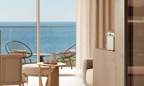 A balcony with a view of the sea, furnished with chairs and a table.