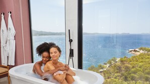 A bathtub with a view of the sea and a towel rack with towels. - TRS Ibiza Hotel - Adults Only +16 (Sant Antoni de Portmany)