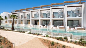 A hotel with multiple balconies, a swimming pool, and a desert landscape. - TRS Ibiza Hotel - Adults Only +16 (Sant Antoni de Portmany)