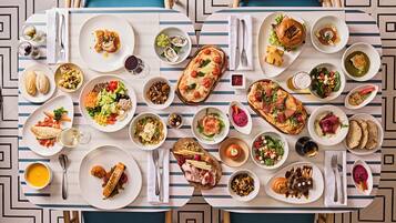 Una mesa de comedor con varios platos y una botella de vino.