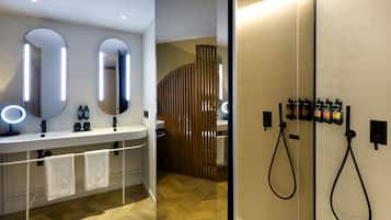A modern bathroom with a vanity, two mirrors, a shower area, and a towel rack.