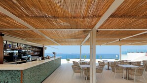 A bar area with a view of the sea, featuring a counter with bottles and a green mosaic backsplash. - TRS Ibiza Hotel - Adults Only +16 (Sant Antoni de Portmany)