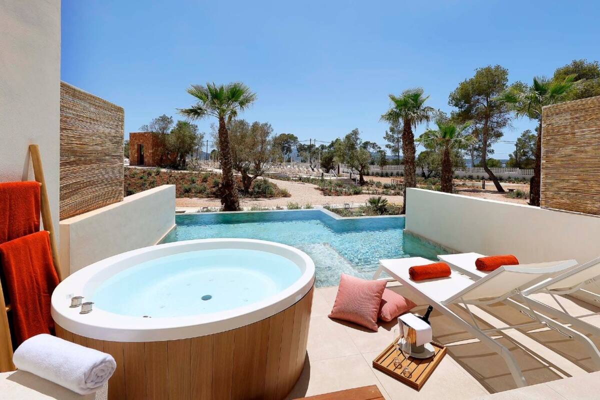 A poolside area with a hot tub, lounge chairs, and towels.