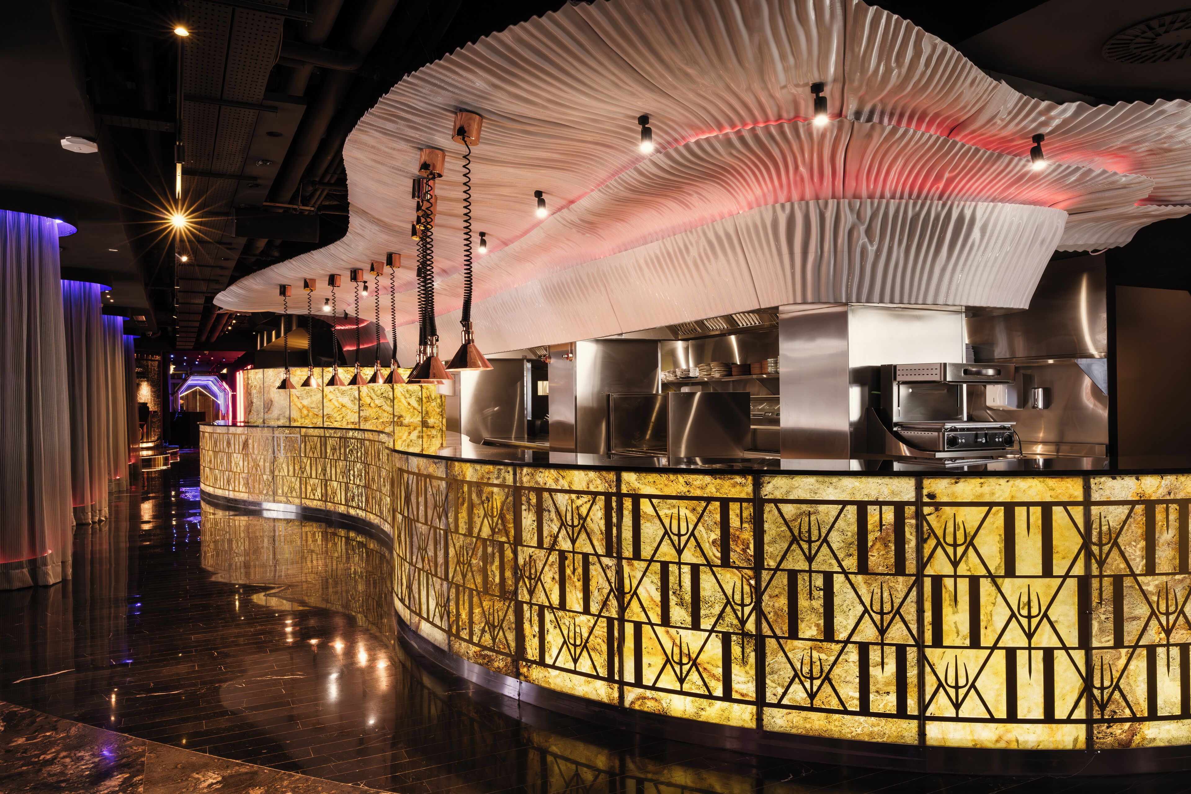 Un restaurante moderno con una barra curva, iluminación ambiental y un suelo reflectante.