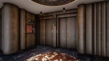 An elevator interior with wooden paneling, a marble floor, and a fire alarm panel.