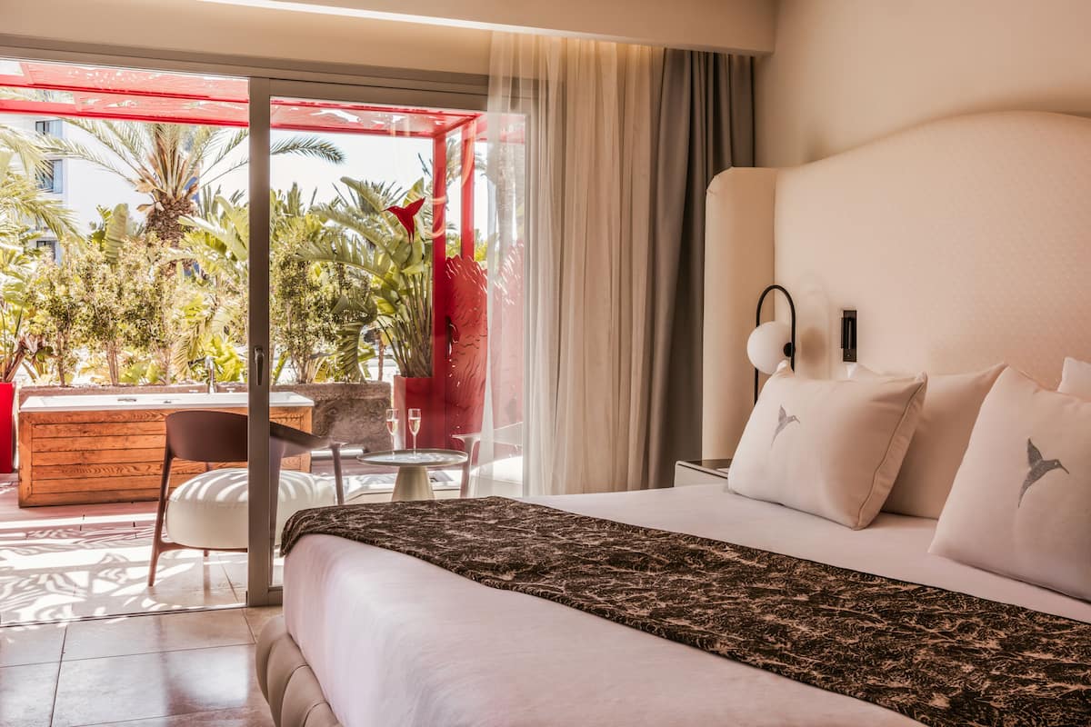 Ein Hotelzimmer mit Bett, Schreibtisch und Blick ins Freie.
