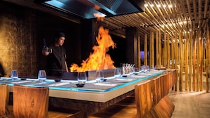 A long wooden dining table with a modern design, surrounded by wooden chairs. - The Unexpected Ibiza Hotel - Ushuaïa Club entrance included (Sant Josep de sa Talaia)