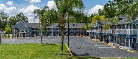 Un hôtel doté d’un parking, de plusieurs bâtiments et d’arbres.