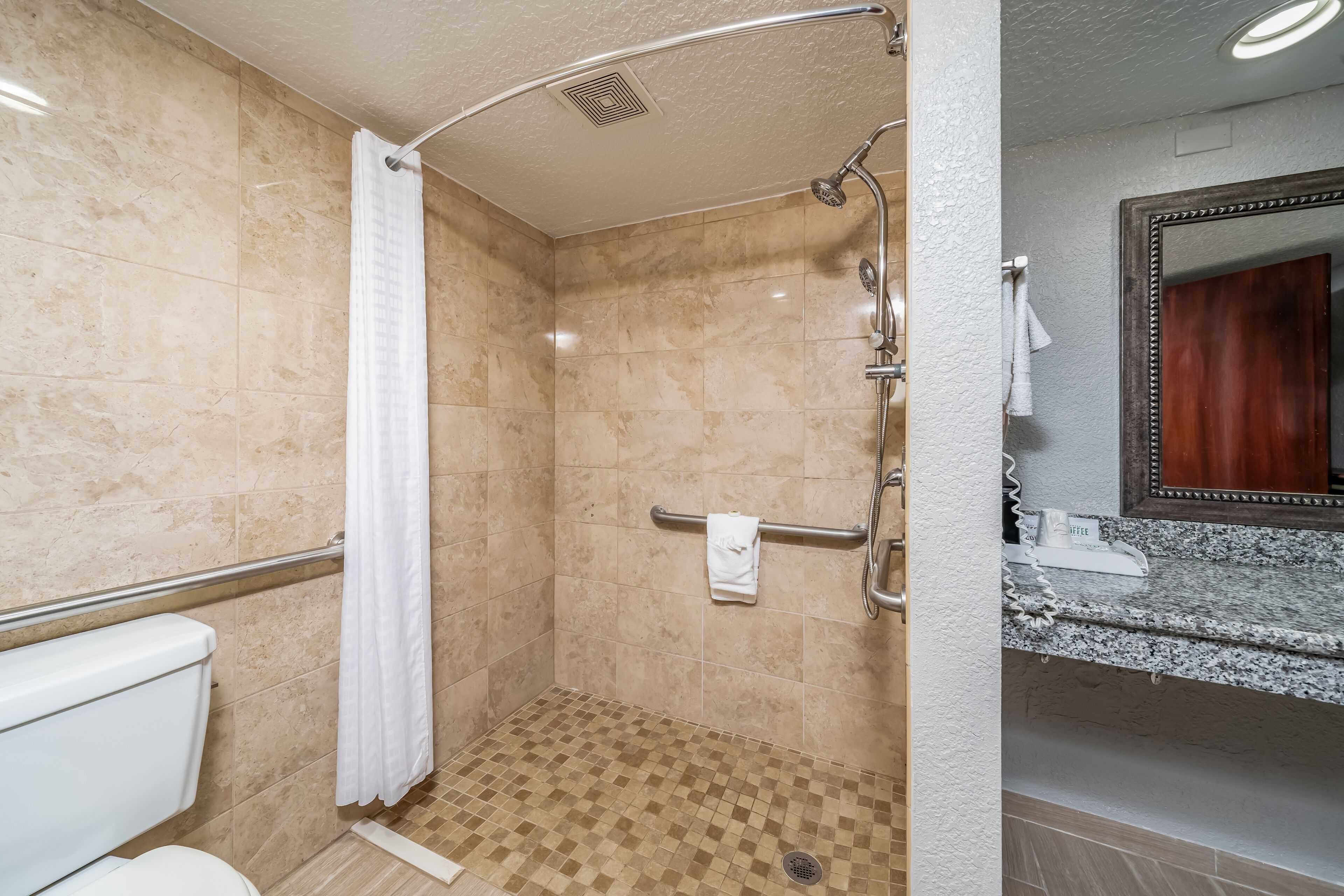 A bathroom with a shower, toilet, and sink.