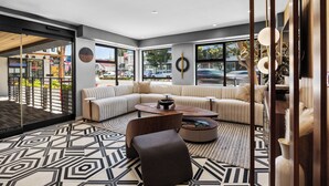 A modern living room with a sectional sofa, a coffee table, and a patterned rug. - Infinity Hotel San Francisco, Tapestry Collection by Hilton (San Francisco)