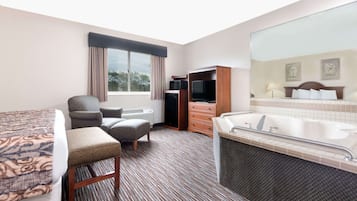A hotel room with a bed, a desk, a chair, a television, a wardrobe, and a bathtub.