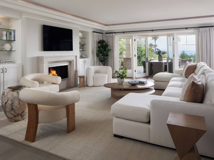 A spacious living room with a fireplace, comfortable seating, and a view of the outdoors.