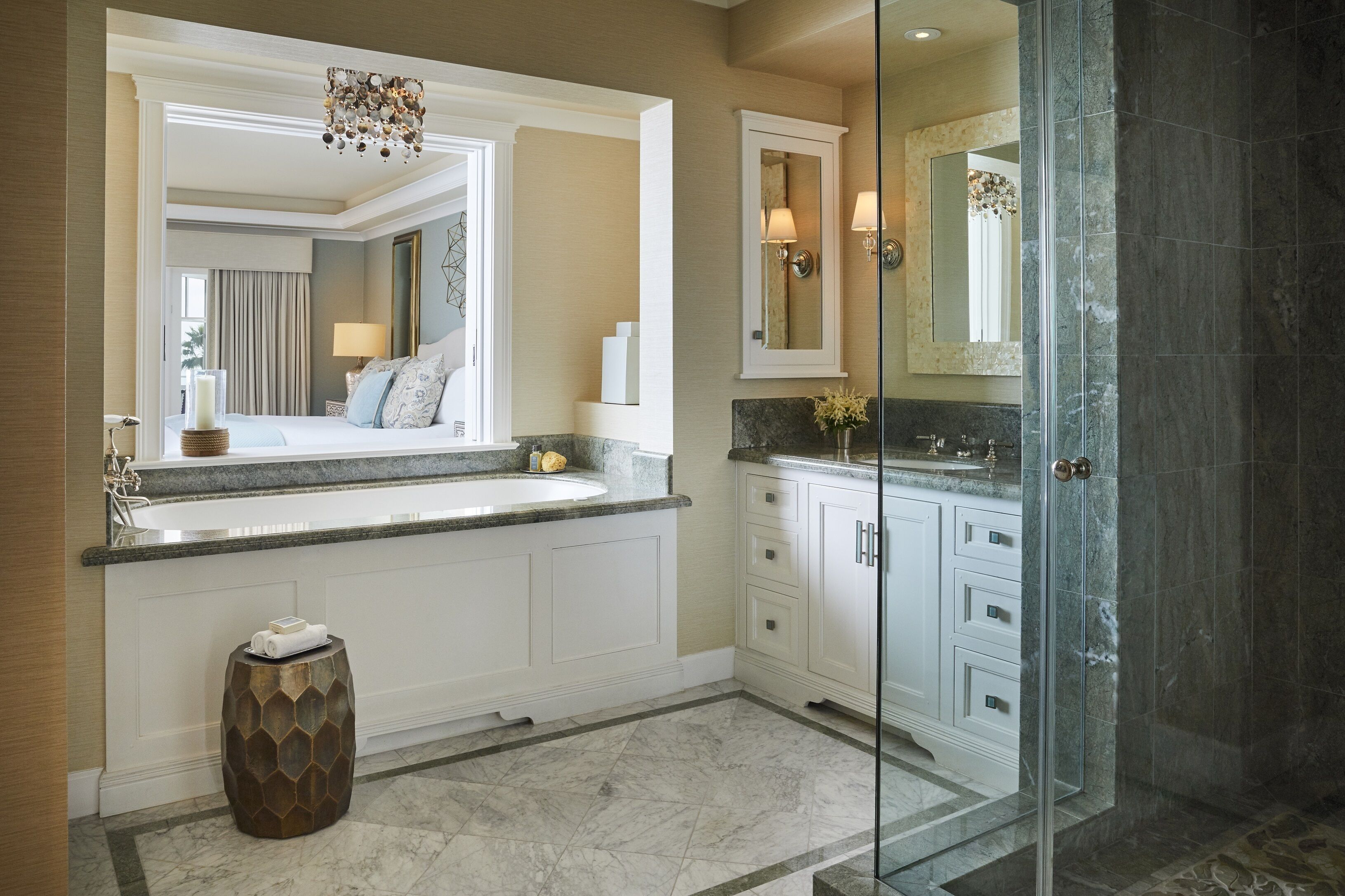 A modern bathroom with a large mirror, a bathtub, and a glass shower enclosure.