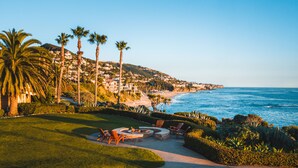 A coastal view with a well-maintained lawn, outdoor seating area, and a fire pit. - Montage Laguna Beach (Laguna Beach)