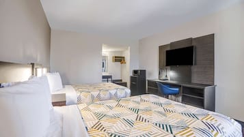 A hotel room with two beds, a desk, a chair, a TV, and a wardrobe.