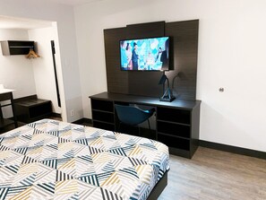A hotel room with a bed, a desk, a chair, a TV, and a wardrobe. - Motel 6 Amarillo, TX - Airport (Amarillo)