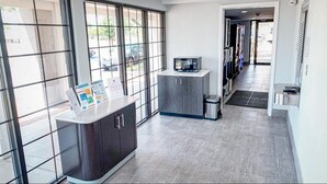A modern kitchen with a microwave on a cabinet, a trash bin, and a small refrigerator. - Motel 6 Amarillo, TX - Airport (Amarillo)
