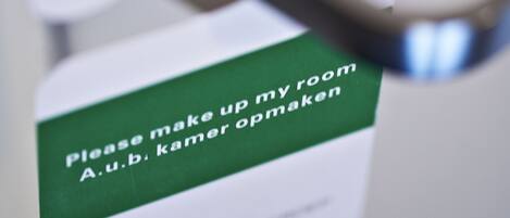A door handle with a sign that reads "Please make up my room A.u.b. kamer opraken."