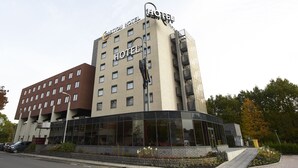 A multi-story hotel with a modern glass facade and a prominent sign on the top. - Bastion Hotel Den Haag Rijswijk (Rijswijk)