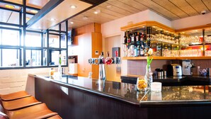 A bar area with a counter, stools, and shelves stocked with bottles and glasses. - Bastion Hotel Schiphol Hoofddorp (Hoofddorp)