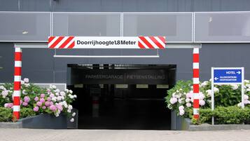 Een gevelingang met een bord waarop staat dat de maximale hoogte 1,8 meter is.