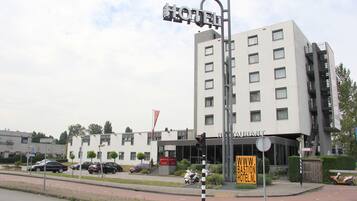 Een modern hotel met een opvallend bord, verschillende verdiepingen en een duidelijke ingang.