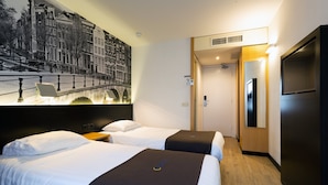 Habitación de hotel con dos camas, un mural grande en la pared, un televisor y piso de madera.