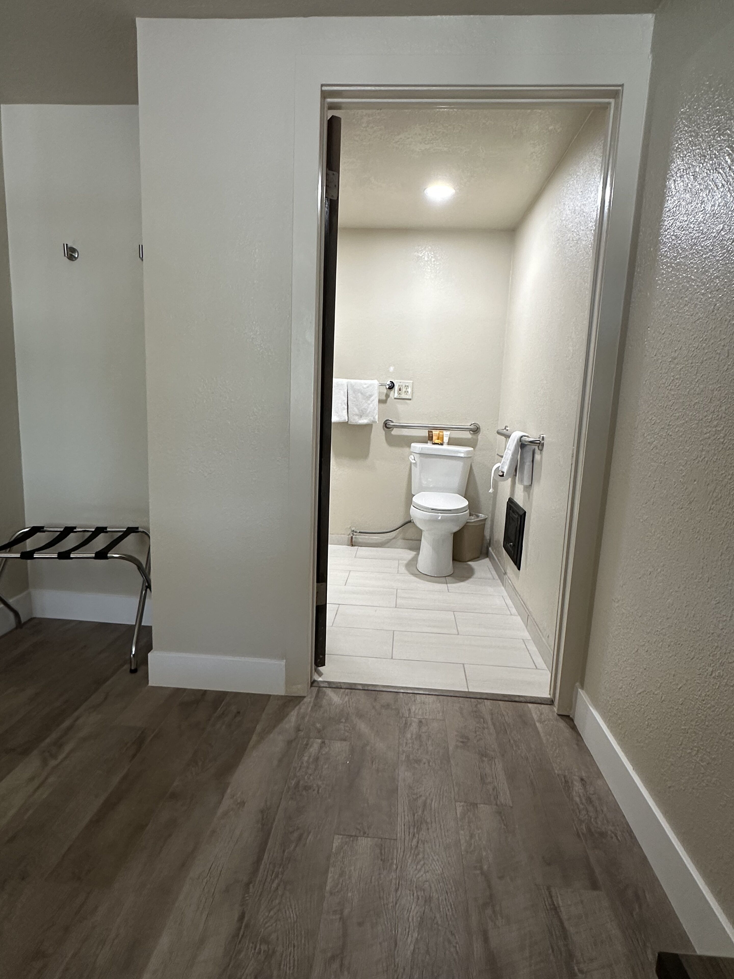 Une salle de bain comprenant des toilettes, un porte-serviettes et un espace douche.