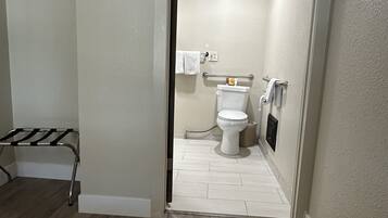 Une salle de bain comprenant des toilettes, un porte-serviettes et un espace douche.