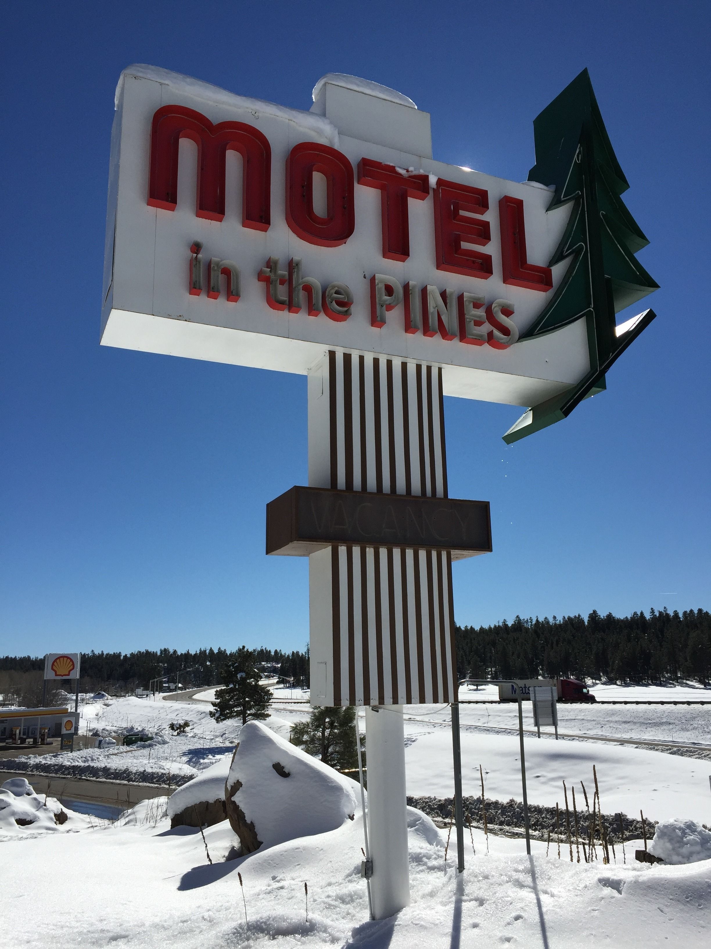 Et motel-skilt med et design af et fyrretræ, der angiver en beliggenhed i Pines.
