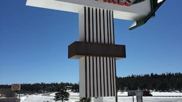 Et motel-skilt med et design af et fyrretræ, der angiver en beliggenhed i Pines.