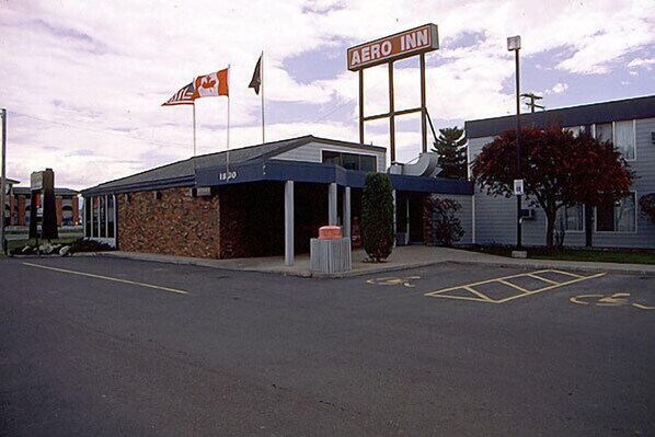 A building with a sign reading "AERO INN" and a flagpole with a Canadian flag.