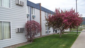 A two-story building with a flat roof, air conditioning units, and a well-maintained lawn. - Aero Inn (Kalispell)