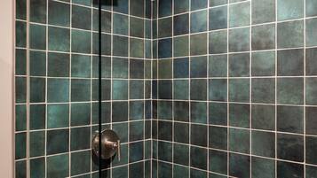 A shower with a glass door and a metal showerhead.