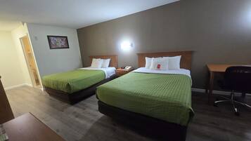 Ett hotellrum med två sängar, ett skrivbord och en stol.