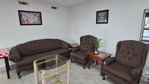 A living room with striped sofas, a glass coffee table, and a small side table with a plant.