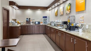 A modern kitchen with a breakfast bar, equipped with coffee makers, a microwave, and a water dispenser. - Comfort Suites Brenham (Brenham)