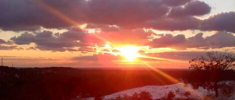 Ein Sonnenuntergang über einer verschneiten Landschaft unter einem klaren Himmel.