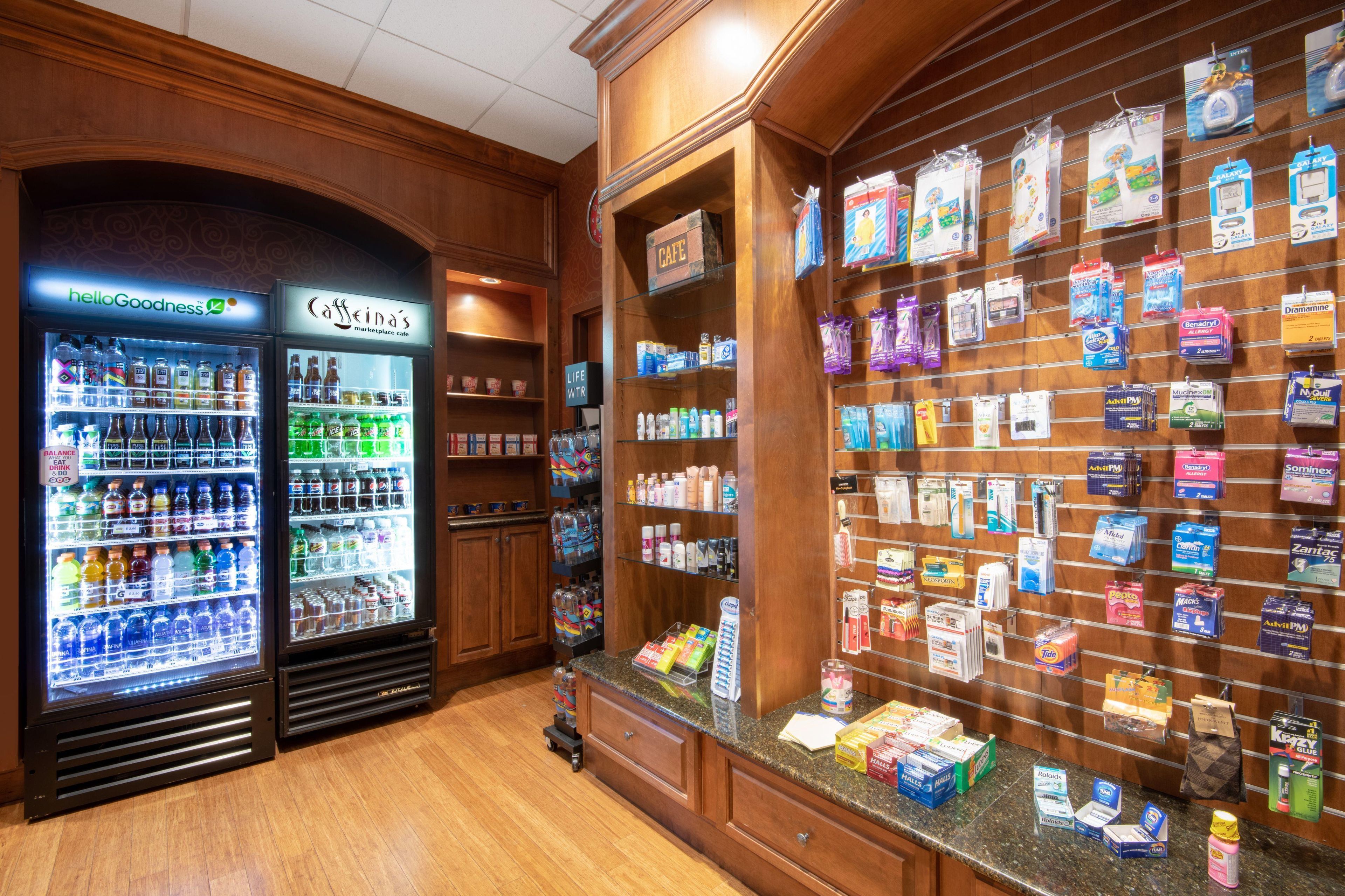 Eine Apotheke mit Getränkekühlschränken, Regalen voller Gesundheitsprodukte und Hygieneartikeln sowie einer Theke mit weiteren Waren.