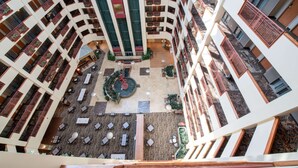 A multi-level atrium with a central courtyard, balconies, and outdoor seating areas.