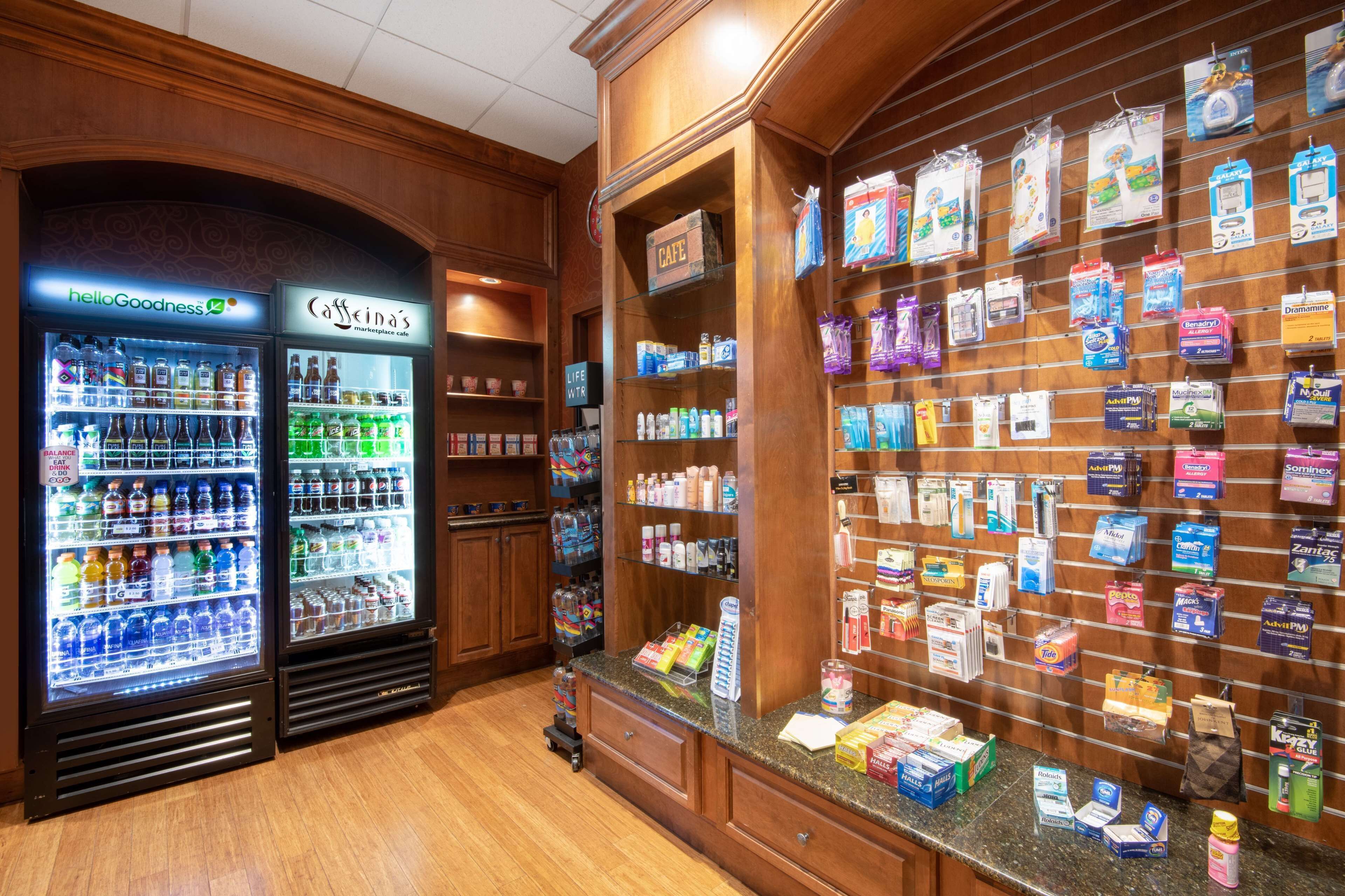 A pharmacy with refrigerated beverage dispensers and a variety of health and wellness products on display.