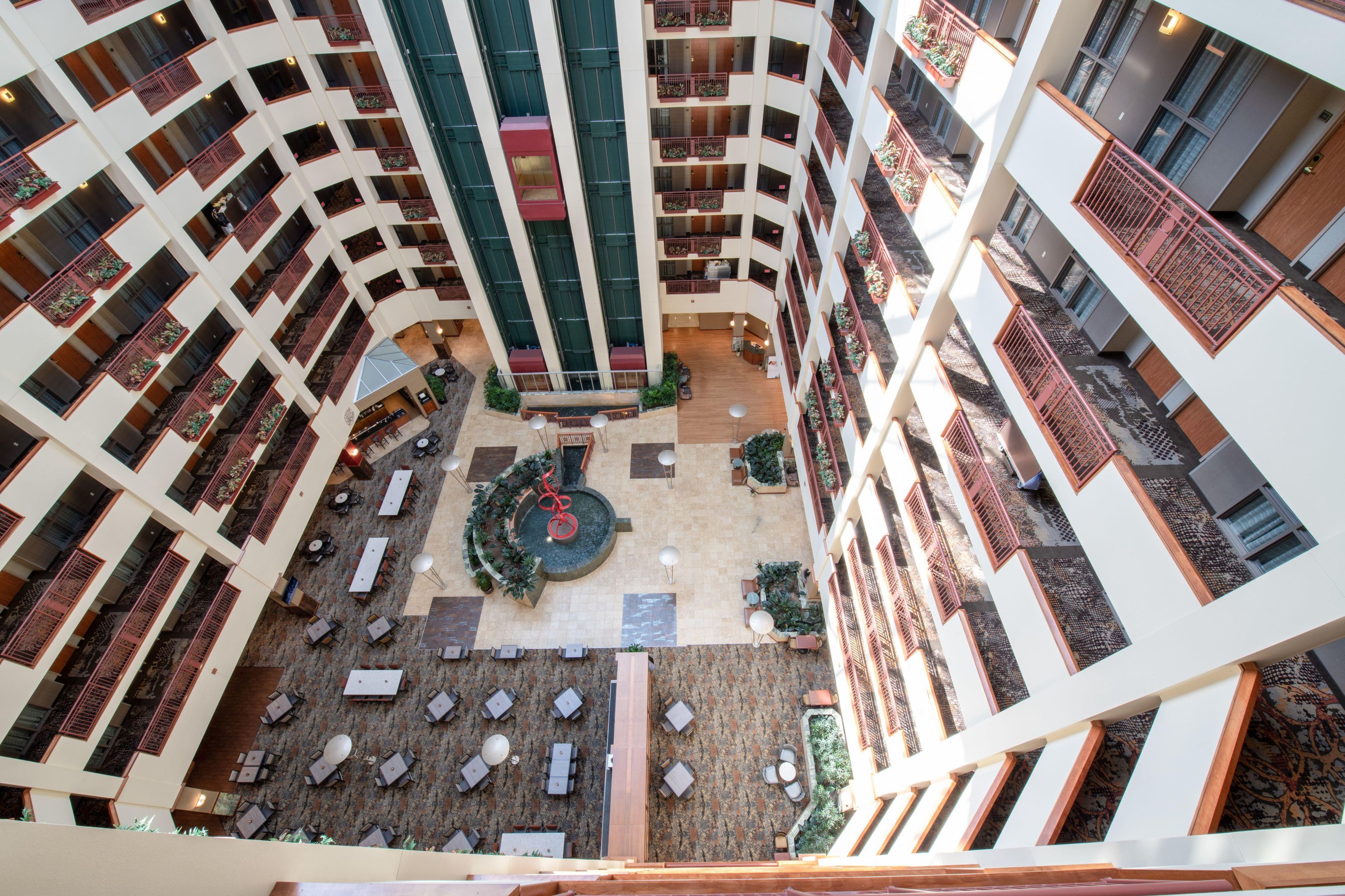 A multi-level atrium with a central courtyard, outdoor seating, and balconies.