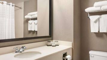 A bathroom with a sink, mirror, towel rack, and toilet.