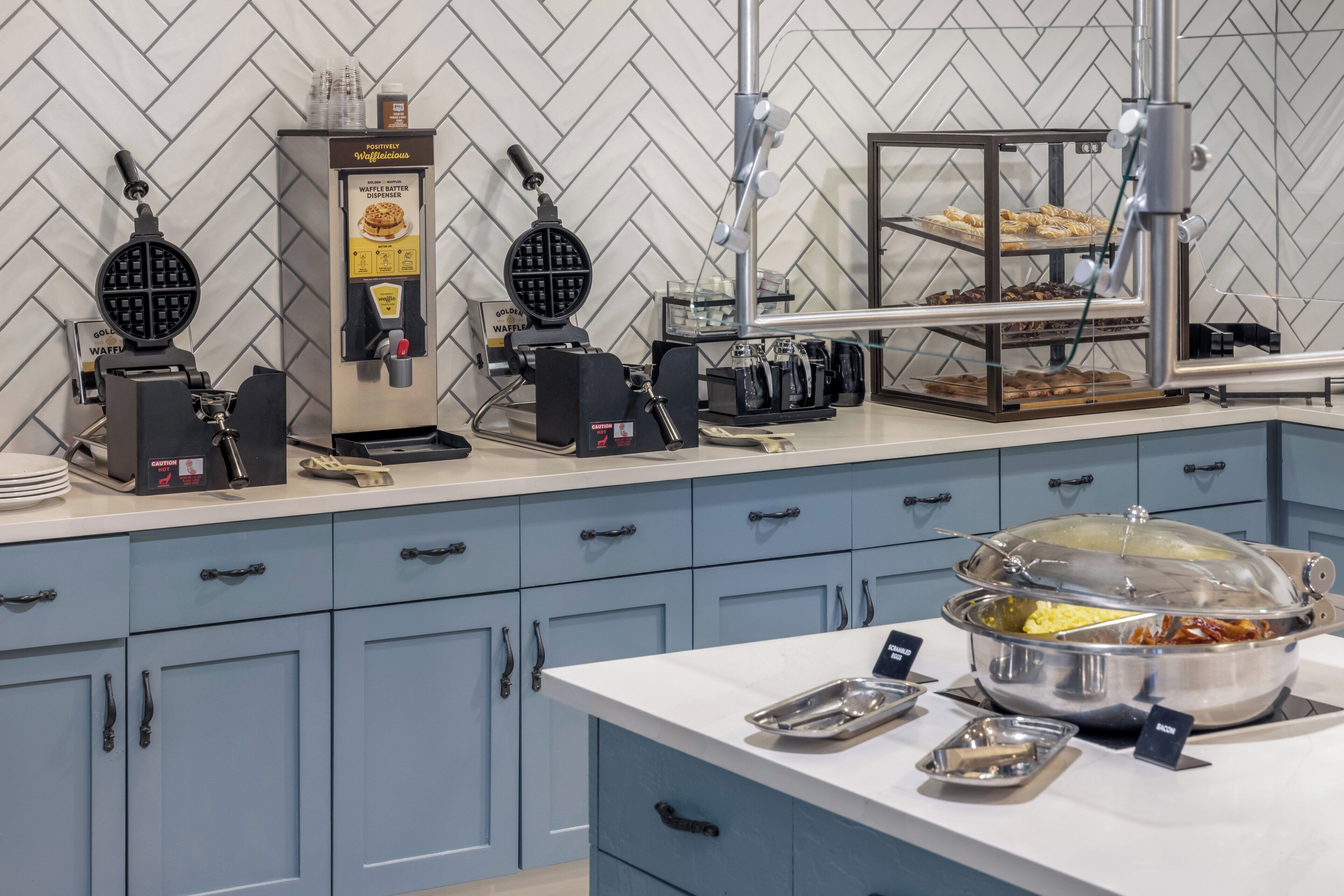 A waffle station with waffle makers and a waffle batter dispenser.