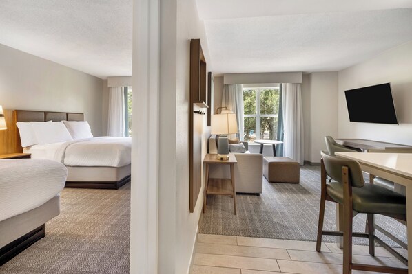 A hotel room with a bed, a desk, a chair, a TV, and a window. - Staybridge Suites Pensacola Airport by IHG (Pensacola)