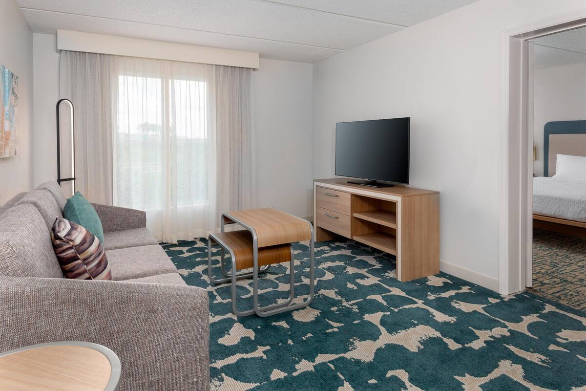 Une chambre d’hôtel avec un canapé, une télévision, un bureau et un lit.