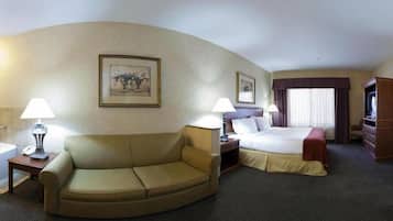 A hotel room with a sofa, a bed, a desk, and a television.