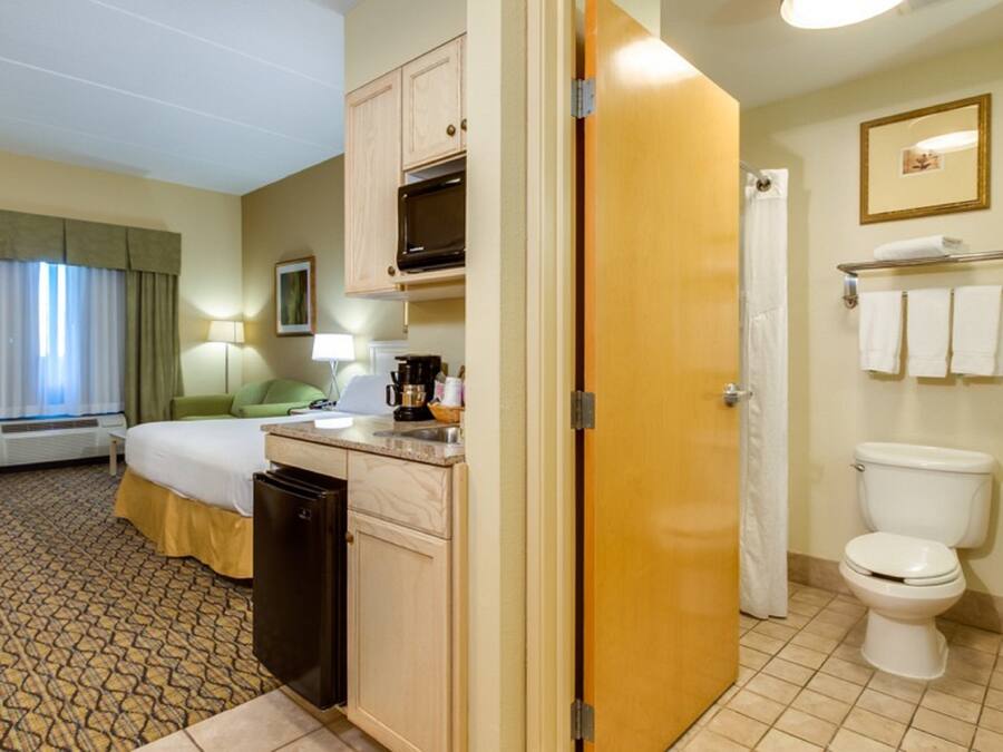 Een hotelkamer met een bed, kitchenette en badkamer.