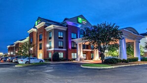 A Holiday Inn Express hotel with a brick facade, large columns, and a parking lot. - Holiday Inn Express Hotel & Suites Memphis Southwind by IHG (Memphis)