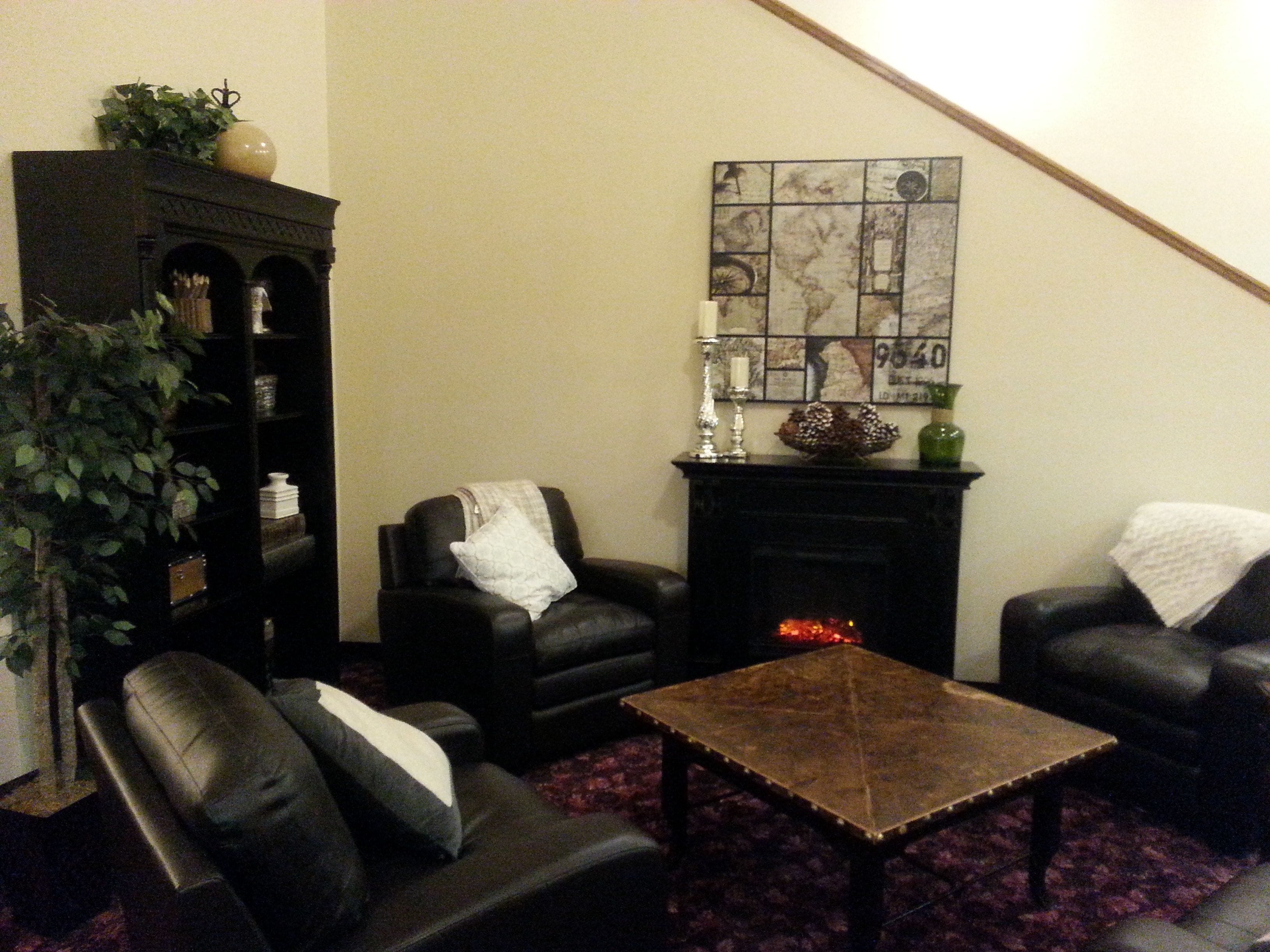 A living room with a fireplace, a bookshelf, and a coffee table.